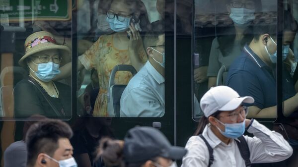 Люди в масках в автобусе в Пекине  - Sputnik Mundo