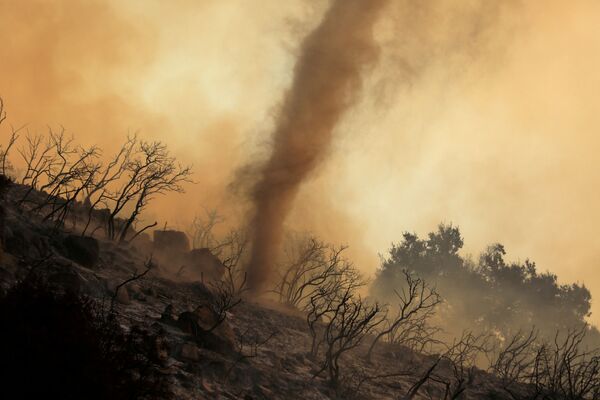 Un tornado de cenizas y ascuas se mueve a través de un incendio forestal en California. - Sputnik Mundo