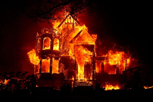 Una casa en llamas durante un incendio forestal a gran escala en el Norte de California. - Sputnik Mundo