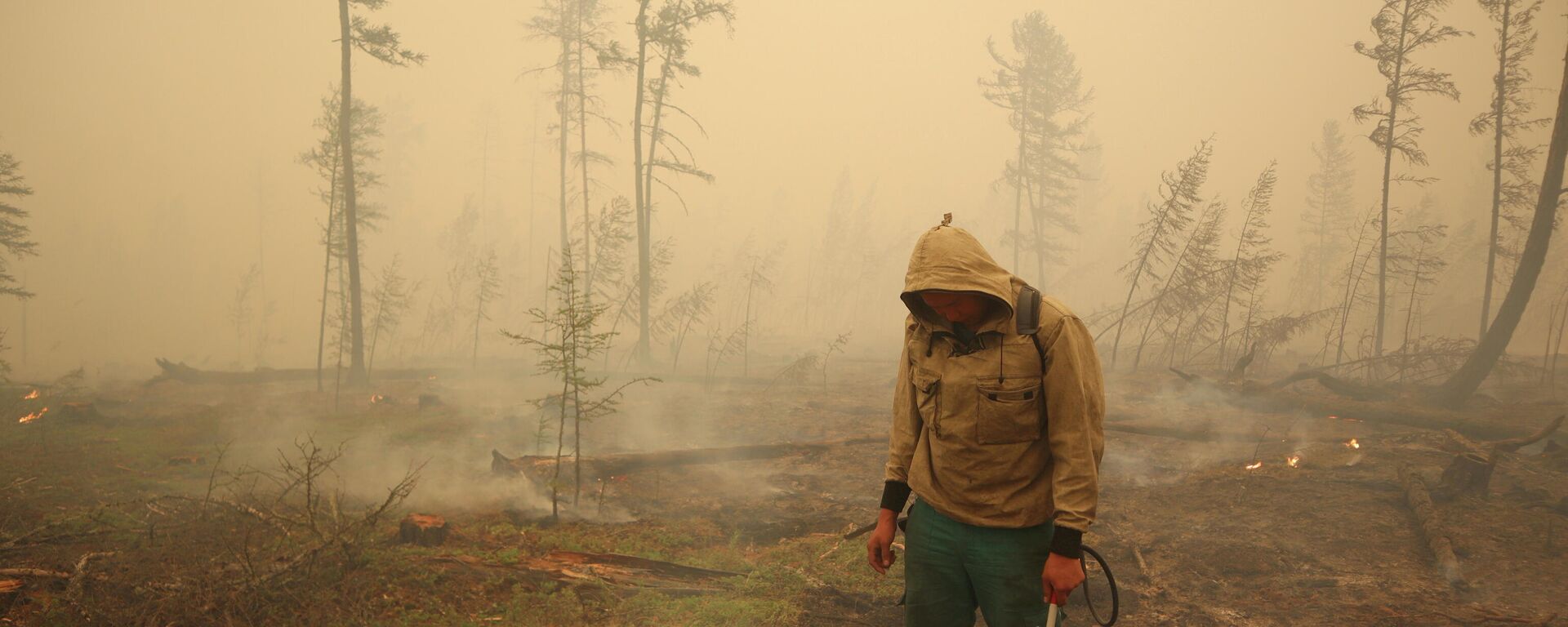 Un especialista del servicio local de protección forestal extingue un incendio forestal cerca del pueblo de Magaras en la región de Yakutia, Rusia, el 17 de julio de 2021 - Sputnik Mundo, 1920, 19.08.2021
