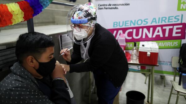 La trabajadora de salud Carla Díaz vacuna a Joel Villalba, de 17 años, con una dosis de la vacuna Moderna contra el coronavirus (COVID-19) en un centro de vacunación, en Buenos Aires, Argentina, el 9 de agosto de 2021 - Sputnik Mundo