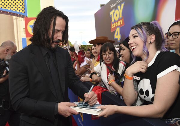 Si bien es zurdo, el actor Keanu Reeves, al igual que Lady Gaga, sabe tocar la guitarra a la diestra.En la foto: Keanu Reeves firma autógrafos antes del estreno mundial de Toy Story 4 en Los Ángeles (EEUU), 2019. - Sputnik Mundo