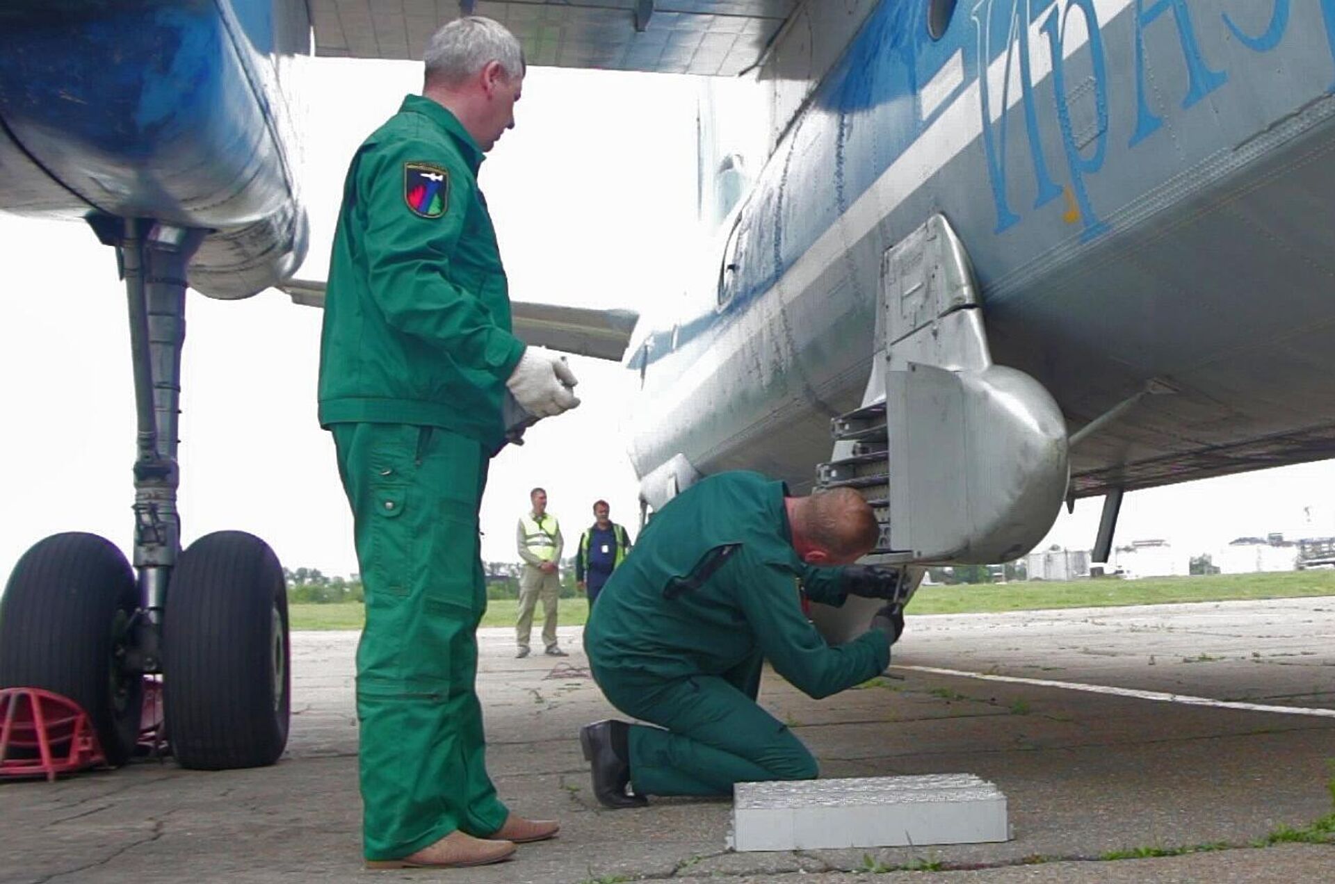 Unos trabajadores instalan cartuchos de yoduro de plata en el avión An-26 Tsiklon - Sputnik Mundo, 1920, 15.08.2021