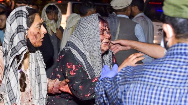 Mujeres lloran a los heridos y fallecidos en el ataque terrorista en Kabul. - Sputnik Mundo