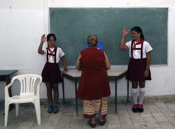 En Cuba, los uniformes son obligatorios no sólo para los escolares sino también para los estudiantes. Se puede saber en qué grado está un niño por su color. - Sputnik Mundo