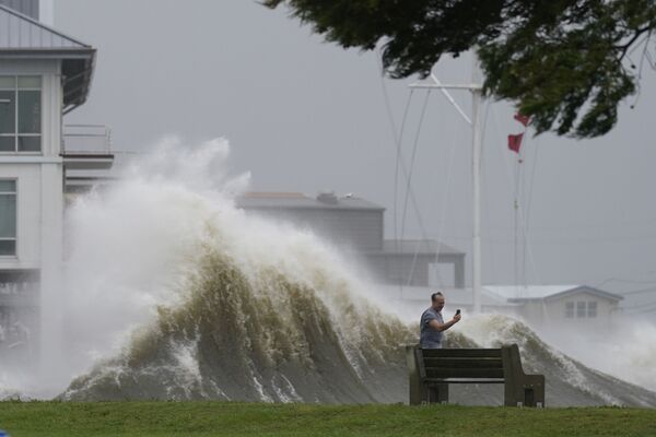 Un hombre toma fotos de las altas olas a lo largo de la orilla del lago Pontchartrain, mientras se acerca el huracán Ida, el 29 de agosto de 2021, en la ciudad de Nueva Orleans, EEUU. - Sputnik Mundo
