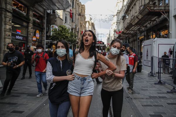 La Policía antidisturbios detiene a una manifestante en una acción de protesta con motivo del Día Mundial de la Paz, en Estambul. - Sputnik Mundo