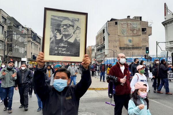 Un manifestante lleva un cuadro con la foto de Salvador Allende - Sputnik Mundo