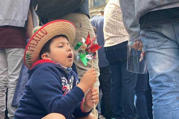 Un niño espera el inicio del desfile militar jugando con un rehilete con los colores de la bandera mexicana - Sputnik Mundo