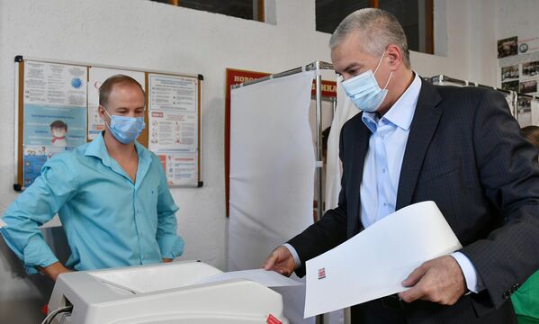 El presidente de la República Autónoma de Crimea, Serguéi Axiónov, entrega su voto en un colegio electoral de la ciudad de Simferópol. - Sputnik Mundo