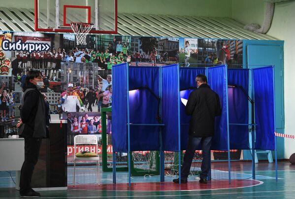 Un hombre vota en uno de los colegios electorales de Moscú. - Sputnik Mundo