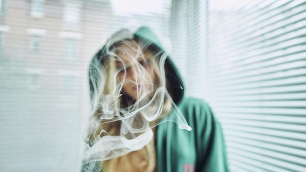 Una mujer entre el humo de un cigarro - Sputnik Mundo