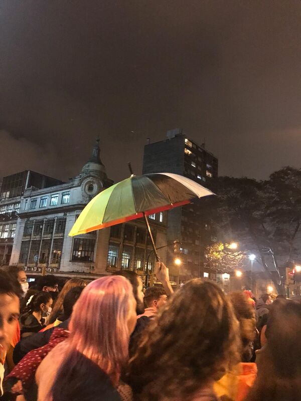 Un paraguas se eleva entre la multitud, luego de que comenzara a llover levemente.  - Sputnik Mundo