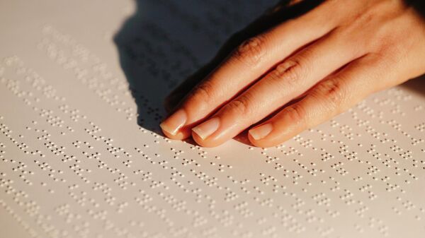 Una persona leyendo en braille - Sputnik Mundo