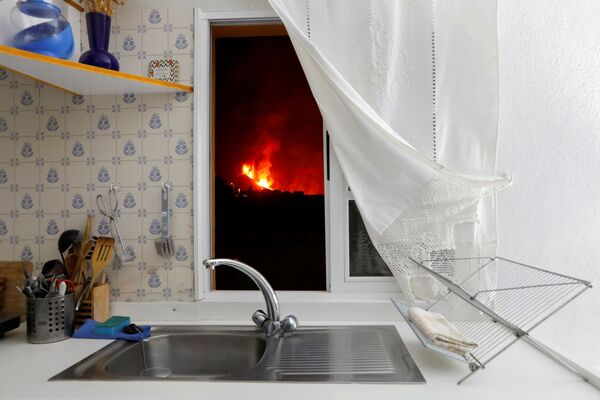 Vista desde la ventana de una vivienda a la lava del volcán Cumbre Vieja en La Palma, parte de las islas Canarias, España. - Sputnik Mundo