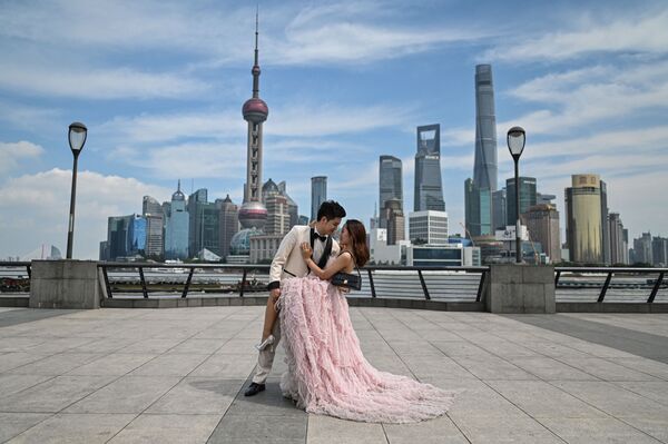 Recién casados durante una sesión de fotos de boda en el paseo marítimo de Shanghái, China. - Sputnik Mundo