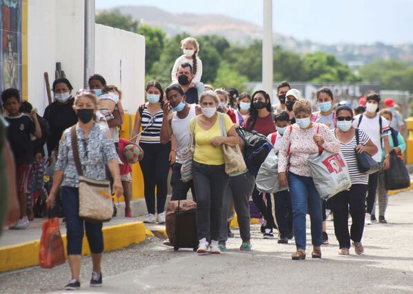 Unos colombianos autorizados para entrar en el país por razones humanitarias cruzan el puente Simón Bolívar. - Sputnik Mundo