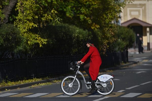Una muchacha monta una bicicleta cerca del convento Novodevichy, un popular punto turístico de la capital rusa. - Sputnik Mundo
