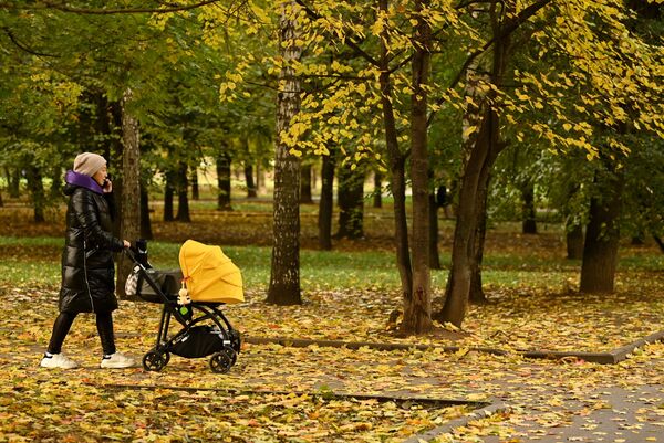 Una mujer con un cochecito de bebé camina en el parque Krasnaya Presnya en Moscú. - Sputnik Mundo