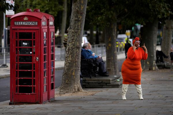 Una modelo posa cerca de una cabina telefónica en Londres. - Sputnik Mundo