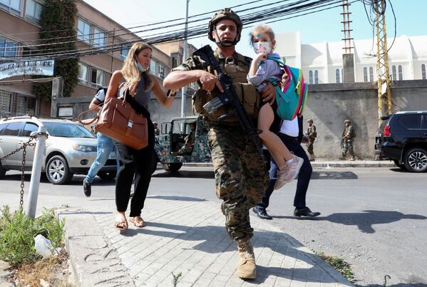 Un soldado ayuda a unos civiles a salir de la zona de un tiroteo en Beirut (Líbano). - Sputnik Mundo