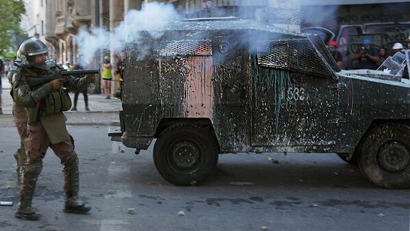 Fuerzas Especiales de Carabineros de Chile disparando bombas lacrimógenas a los cuerpos de los manifestantes.  - Sputnik Mundo