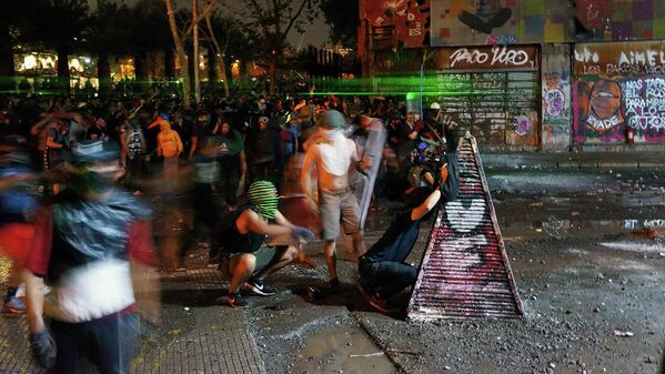 Manifestantes se enfrentan a Fuerzas Especiales de Carabineros en calle Ramón Corvalán Melgarejo esquina Alameda, Santiago de Chile. - Sputnik Mundo