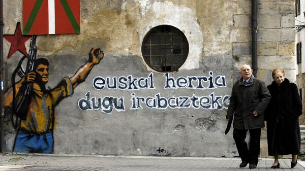 Una pareja camina delante de un mural en apoyo a ETA de Alsasua (Navarra) - Sputnik Mundo