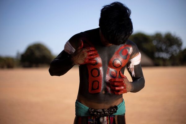 Un hombre de la tribu yawalapiti durante el kuarup en el Parque Nacional Indígena de Xingu, en Brasil. - Sputnik Mundo