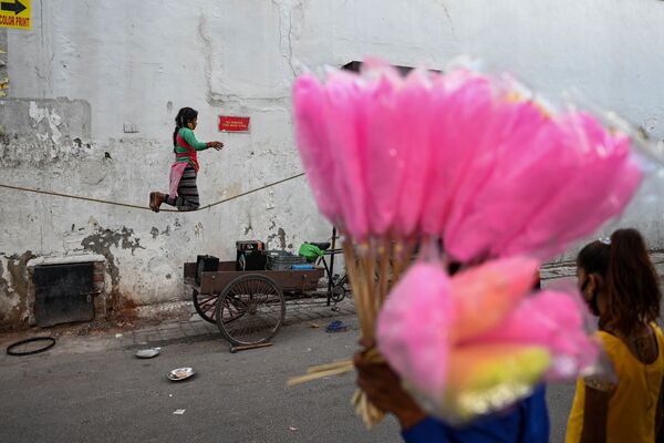 Una niña se balancea sobre una cuerda floja en una calle de Nueva Delhi. - Sputnik Mundo