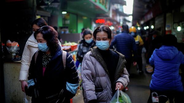 Personas con mascarillas en un mercado callejero en los primeros meses del brote del coronavirus en Wuhan, provincia de Hubei, China, el 8 de febrero de 2021 - Sputnik Mundo