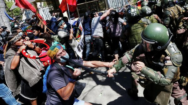 Carabineros de Chile golpean a manifestantes que protestan por la muerte de un comunero mapuche en el sur del país - Sputnik Mundo