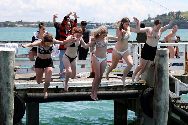 La gente salta al agua desde el muelle de Orakei con la reducción de las restricciones por coronavirus en Auckland (Nueva Zelanda), el 10 de noviembre de 2021. - Sputnik Mundo