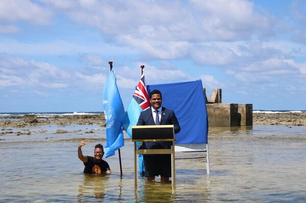 El ministro de Justicia, Comunicación y Relaciones Exteriores de Tuvalu, Simon Kofe, interviene durante la COP26 metido en las aguas del océano en Funafuti, un atolón que forma la capital de Tuvalu, el 5 de noviembre de 2021. - Sputnik Mundo