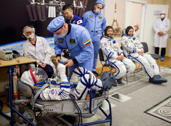 Yusaku Maezawa, Alexandr Misurkin y Yozo Hirano ponen a prueba sus trajes espaciales. - Sputnik Mundo