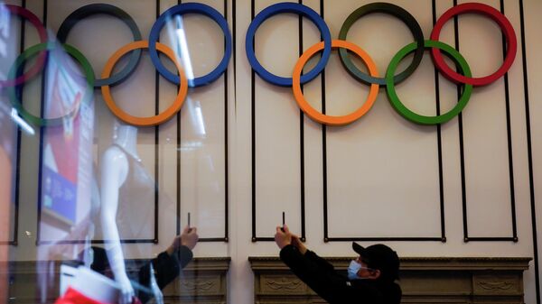 Un visitante toma fotografías cerca de los anillos olímpicos exhibidos en el Museo del Deporte de Shanghái, China, el 8 de diciembre de 2021 - Sputnik Mundo