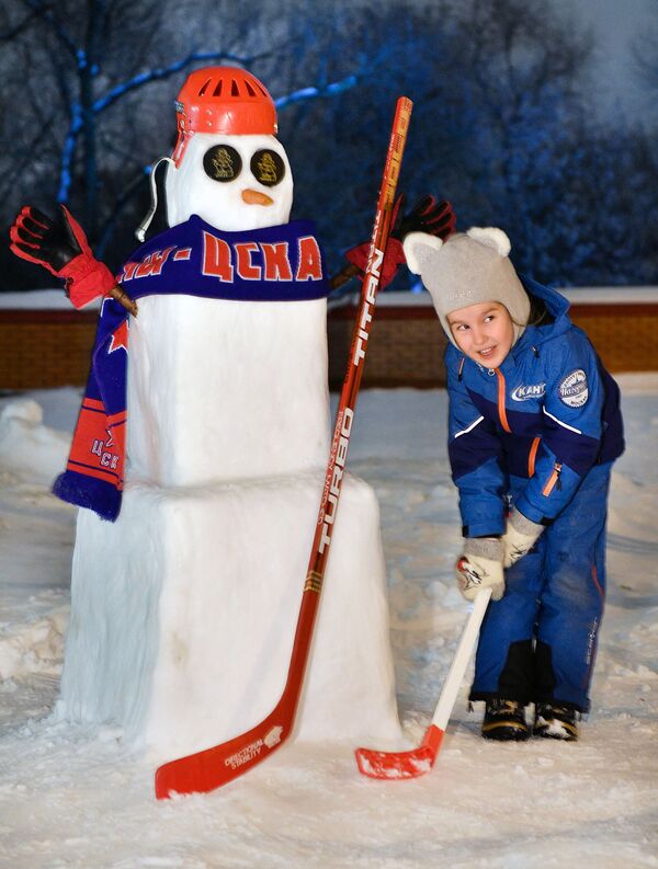 Una niña posa al lado de un muñeco de nieve vestido de uniforme del equipo moscovita CSKA, en Moscú, Rusia, el 17 de diciembre de 2021. - Sputnik Mundo