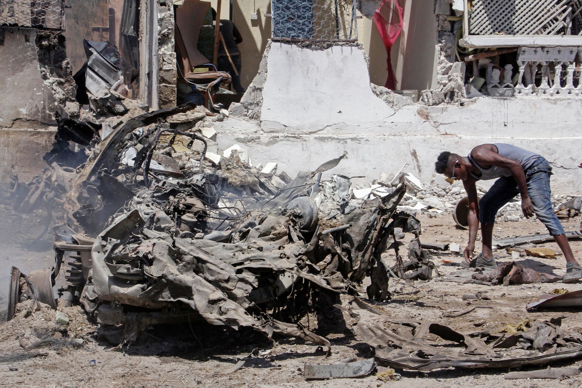 Un hombre busca entre los restos de una explosión en Mogadiscio - Sputnik Mundo, 1920, 12.01.2022