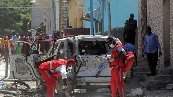 Los paramédicos se preparan para poner el cuerpo de un hombre muerto en una bolsa para cadáveres en la escena de una explosión en Mogadiscio (Somalia), el 16 de enero de 2022 - Sputnik Mundo