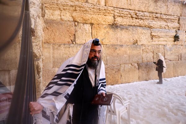 En la tarde del 27 de enero cayó una lluvia fría que arrastró parte de la nieve y desbloqueó las carreteras. En la foto: un judío ortodoxo en el Muro de las Lamentaciones en Jerusalén. - Sputnik Mundo