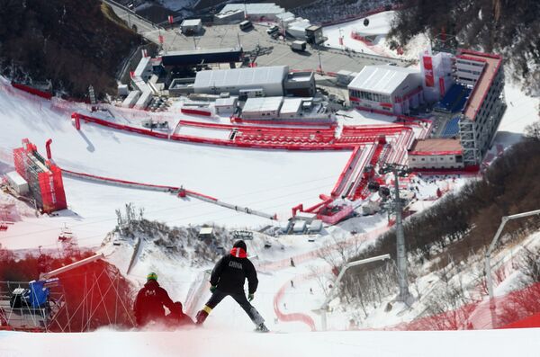 Miembros del personal de mantenimiento comprueban el recorrido antes de la competición de descenso en el Centro Nacional de Esquí de Yanqing. - Sputnik Mundo