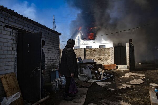 Una casa arde en llamas en el pueblo de Varvárovka, en la región de Lugansk, ubicada al sureste de Ucrania. - Sputnik Mundo