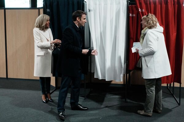 El presidente francés en funciones, Emmanuel Macron, y su esposa, Brigitte Macron, antes de votar en un colegio electoral en Le Touquet, en el norte de Francia. - Sputnik Mundo