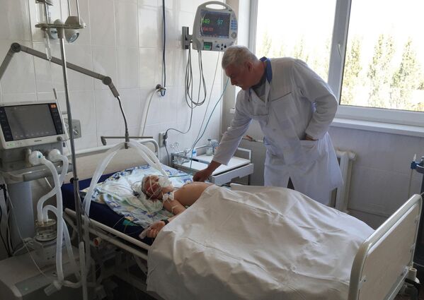 Año 2014: Hospital de Górlovka. Hay muchos niños heridos. Un médico junto a la cama de un niño de 7 años herido por los bombardeos del Ejército ucraniano. - Sputnik Mundo