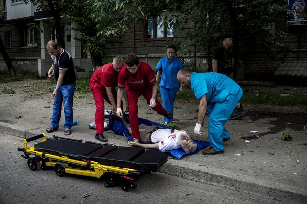 A veces faltaba tiempo para trasladar a los heridos al hospital a tiempo y salvarles la vida.Año 2014: el personal de la ambulancia carga en una camilla a un residente de Lugansk herido en un bombardeo. - Sputnik Mundo