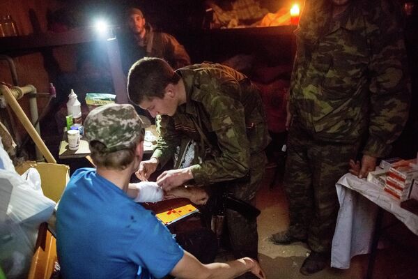 A los médicos les ayudaban las milicias y a veces los propios médicos se unían a las filas de las milicias. Foto del año 2014: un combatiente de las milicias populares ayuda a su compañero herido por los disparos de un tanque en la aldea de Semiónovka, en la región de Donetsk. - Sputnik Mundo