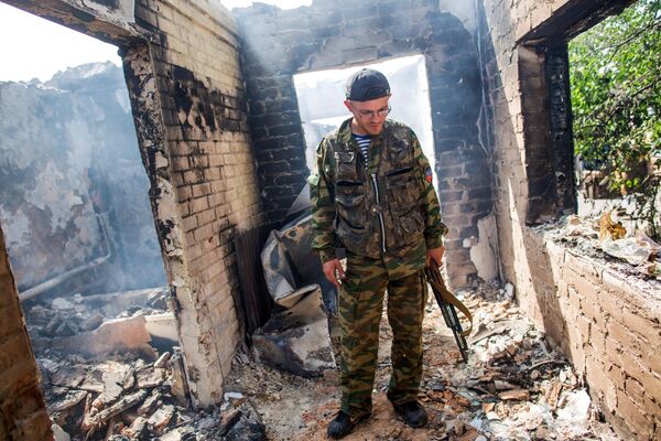 Mayo de 2014. Un miliciano regresó a su casa en el pueblo de Semiónovka, cerca de Slaviansk. Estas ruinas fueron el hogar de su familia. - Sputnik Mundo