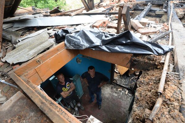 Julio de 2014. El pueblo de Málaia Vergunka. Residentes de una casa destruida por un ataque aéreo del Ejército ucraniano. - Sputnik Mundo
