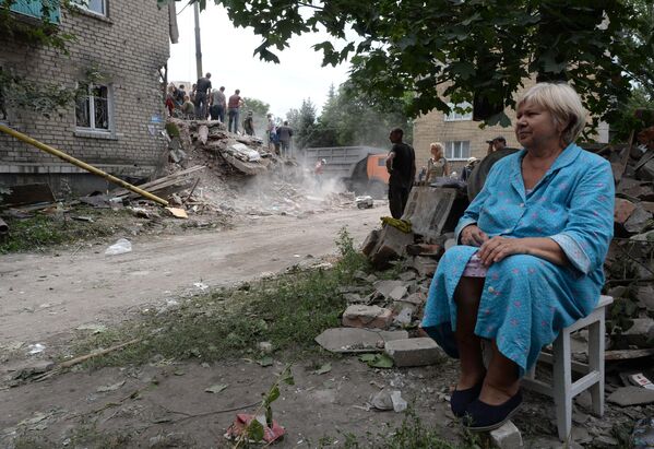 Julio de 2014. La ciudad de Snézhnoe de la región de Donetsk. Una mujer se sienta cerca de las ruinas de su propia casa tras un ataque aéreo ucraniano. - Sputnik Mundo