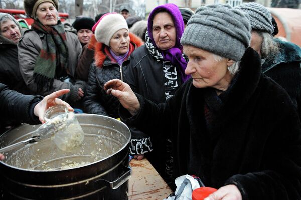 Las cocinas de campaña se han convertido en la única forma de que muchos ancianos reciban una comida caliente en las ciudades destruidas por los bombardeos. En la foto: cola para comprar comida en Debaltsevo. 2015. - Sputnik Mundo